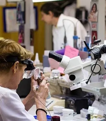 A technician checking a restoration under the microscope.