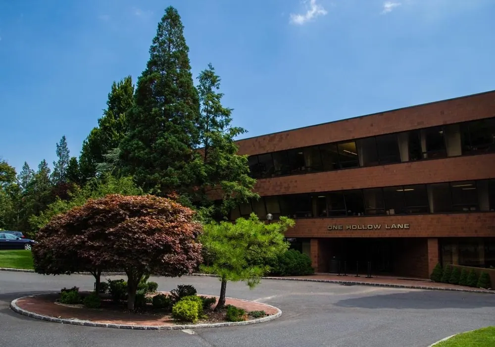 The entrance drive and the One Hollow Lane sign at the Lake Success office building.